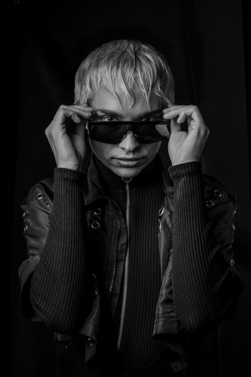 Black-and-white portrait of Charlie Void lowering shield sunglasses